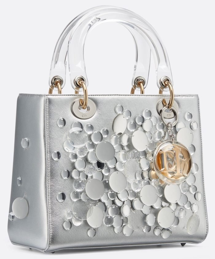 piel de cordero metalizada color plata bordada con lentejuelas transparentes. Charms de metal color oro y plata, sumergidos en acetato transparente.